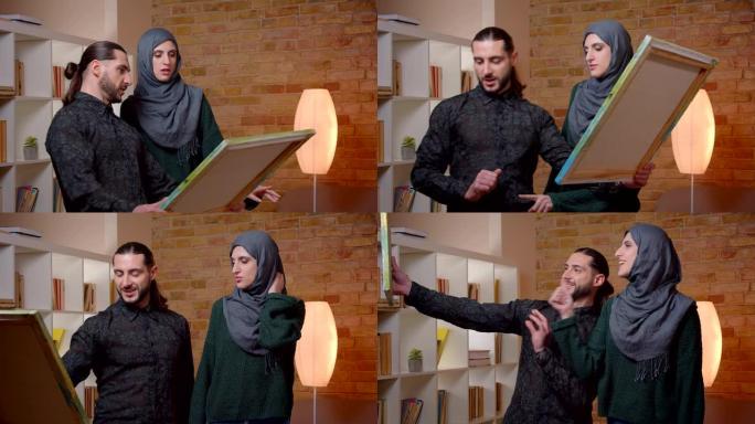 年轻迷人的穆斯林夫妇在室内新买的公寓里定居的特写镜头。男人和女人建议在哪里交照片