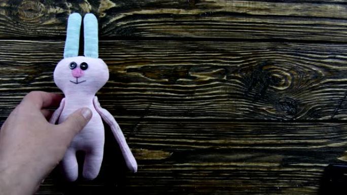 木制背景上的玩具毛绒野兔
