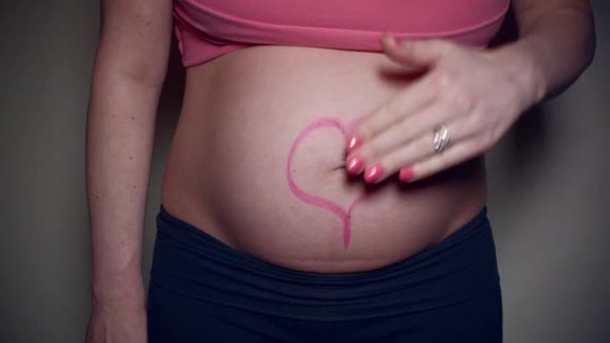母亲怀孕的腹部上有口红心脏的特写视频