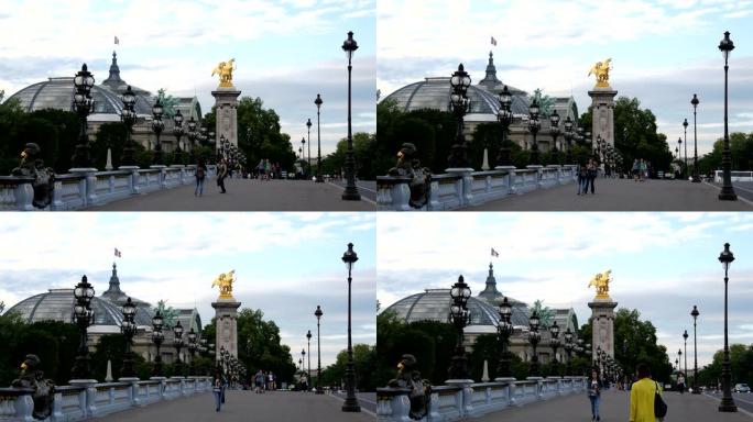 在亚历山大桥 (Pont Alexandre III) 上行走的游客