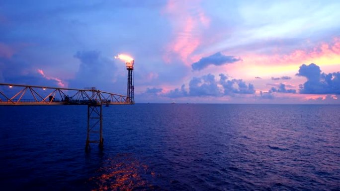 石油和天然气平台的镜头，带有火炬燃烧桥，太阳升起，早晨美丽的云朵，为石油和天然气工业概念。