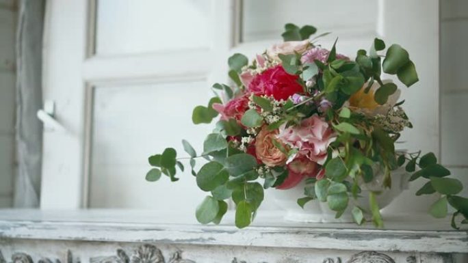 华丽的牡丹和玫瑰花束在窗台上。风吹窗帘