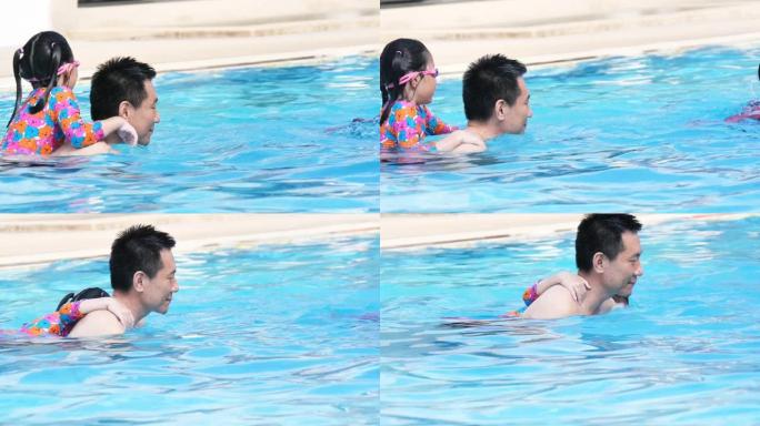 快乐的亚洲父亲和他的孩子在游泳池玩得开心。