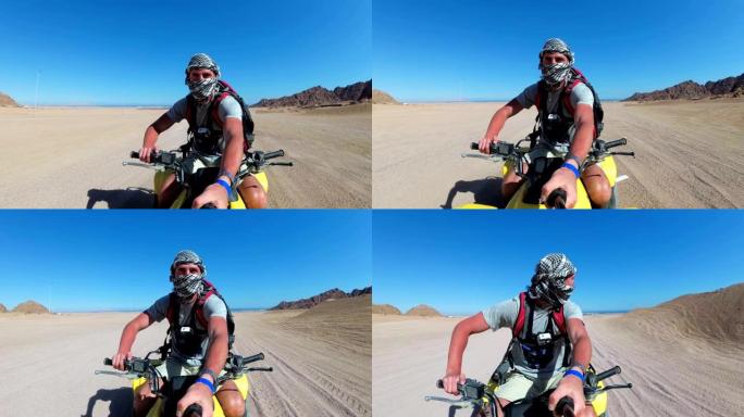 一名男子在埃及沙漠里骑四轮摩托，用动作相机拍摄自己