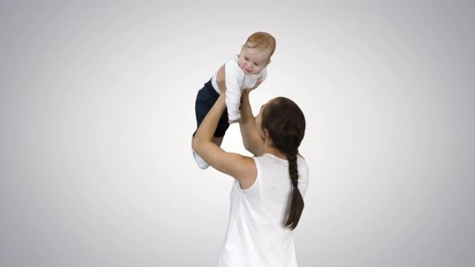 年轻的妈妈通过让他站起来与婴儿玩耍，阿尔法频道