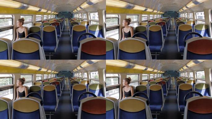 一位美丽的高加索女游客独自坐在空荡荡的地铁车厢里，看着窗外。孤独的概念。慢动作