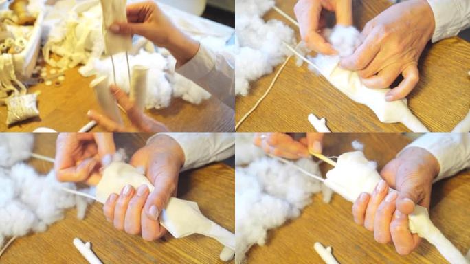 手工娃娃的制作。女人用合成防冬器填充娃娃细节。