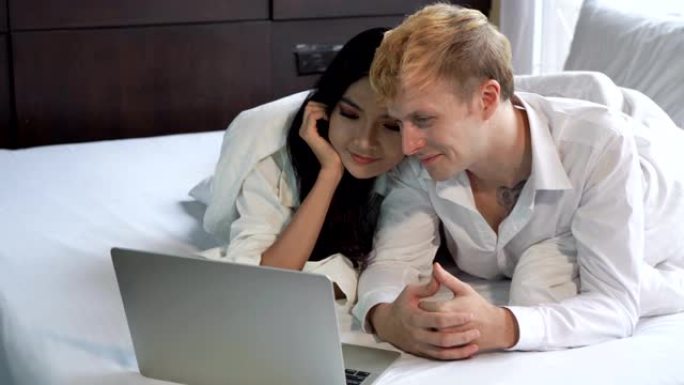 暑假期间，不同国籍、不同年龄的夫妇在她卧室的床上快乐地使用电脑。