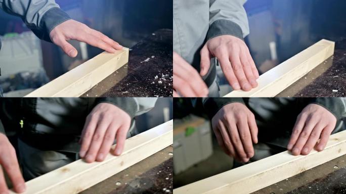 一位男木匠的手的特写检查木板的光滑度和适用性