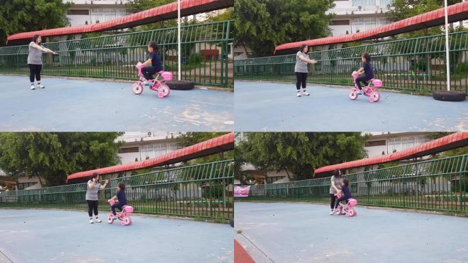 亚裔女儿练习与母亲骑脚踏车