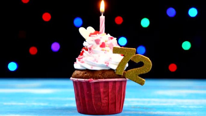 美味的生日蛋糕，蜡烛燃烧，彩色模糊灯光背景上有72号