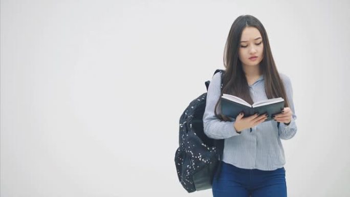 美丽的亚洲年轻少女，肩后背包，看着笔记本，仿佛在地图，戳她的头，消失。
