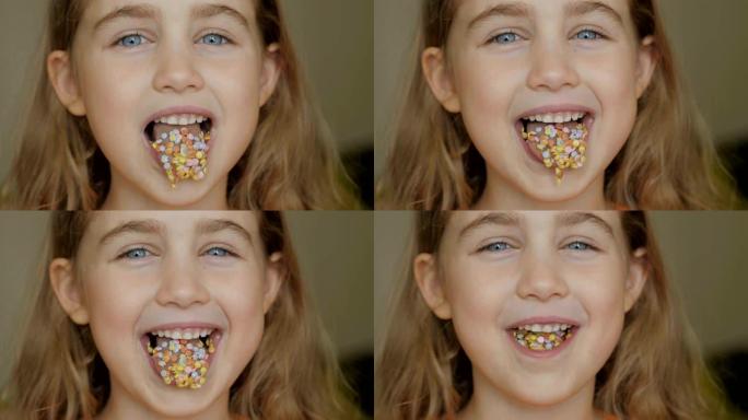 一个孩子笑得满嘴糖果。小女孩在吃糖果。吃小鸡的孩子。特写肖像波浪形头发的傻女孩，尖端伸出舌头形状的糖