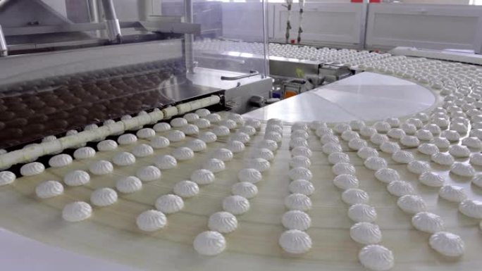 带有大量白色棉花糖的输送机进入巧克力涂层的安装
