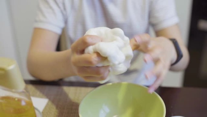 女孩手挤压白色粘液的特写