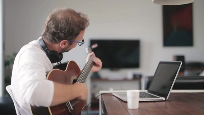 男人在客厅弹吉他。
