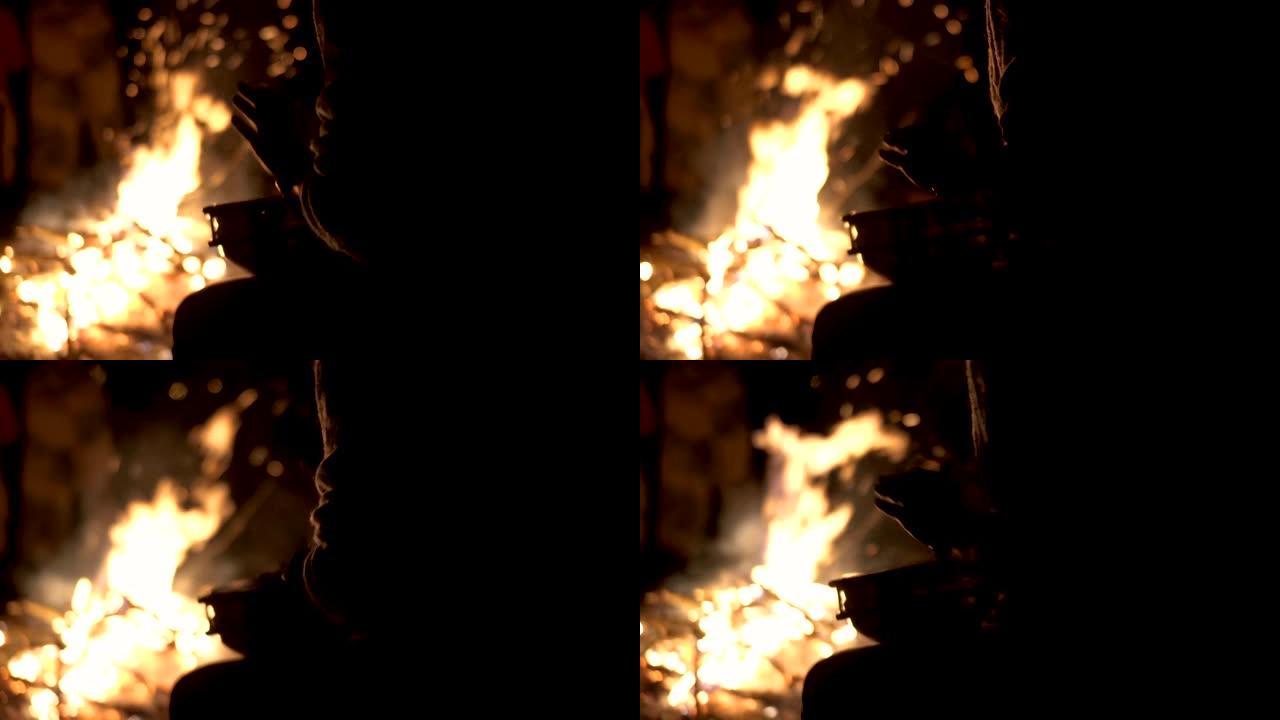 篝火用手在打击鼓上演奏鼓手的剪影