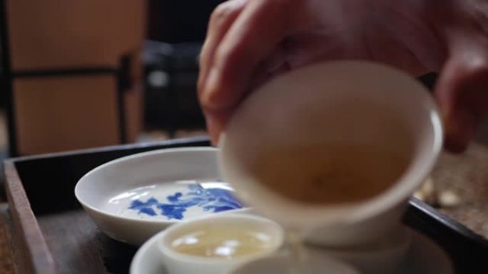 茶师将绿茶倒入茶杯中，以供盖碗或钟。中国传统功夫或功夫茶道。中国传统文化的元素。特写。4k