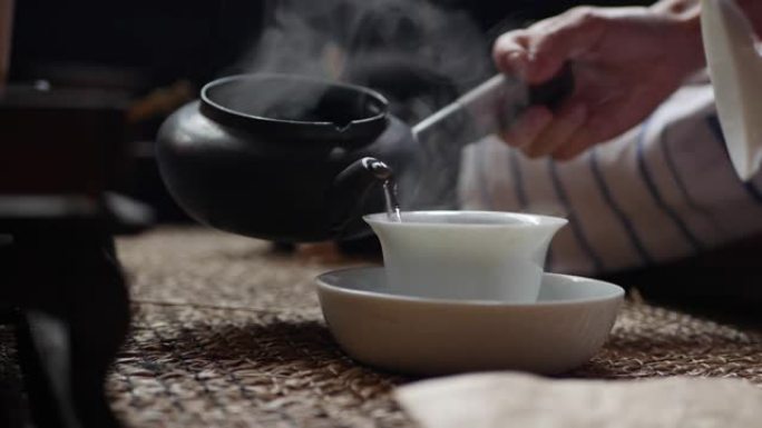中国传统功夫或功夫茶道。开水倒入盖湾。茶师用绿茶将水倒入盖湾或钟。中国传统文化的元素。特写。4k