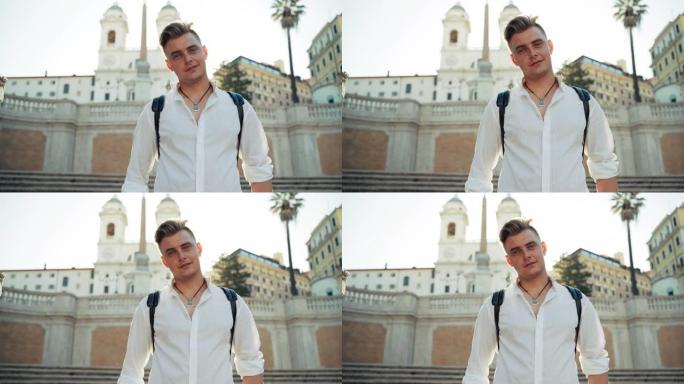 意大利罗马著名的西班牙台阶上的男子肖像特写镜头。微笑的家伙在古老教堂和长墙的背景下看着镜头。街头晨曦
