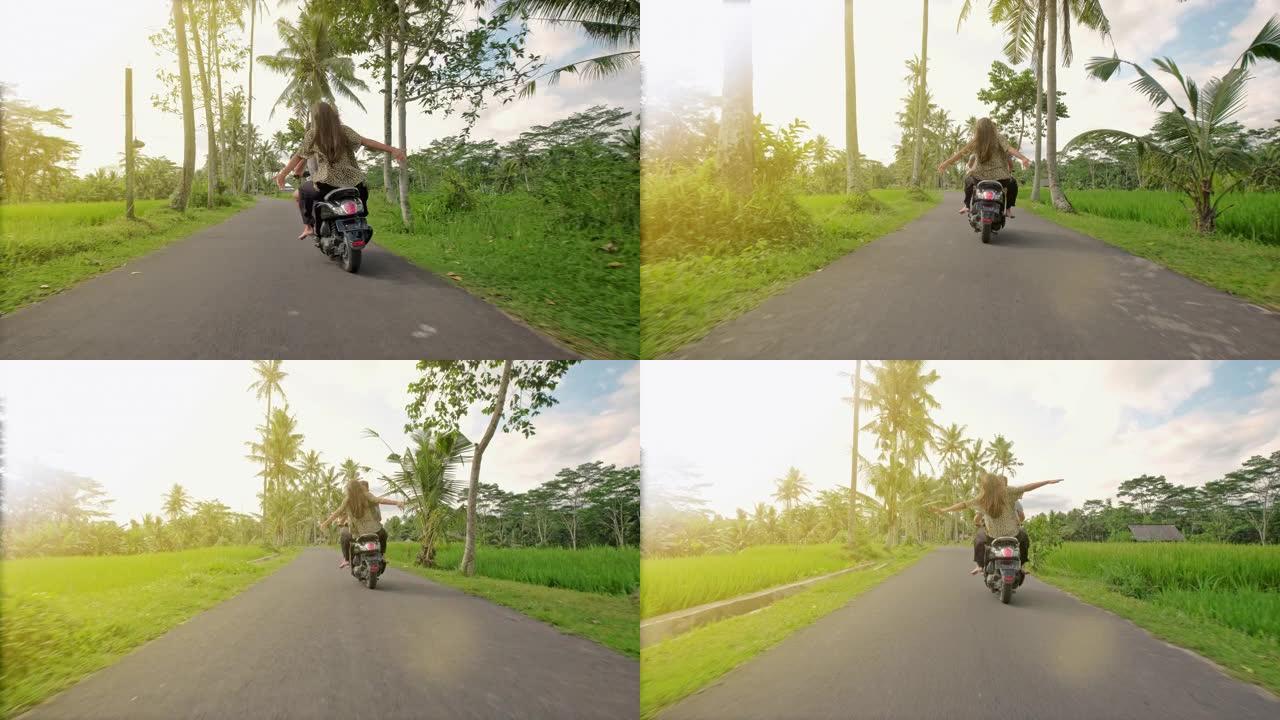 日落时分，幸福的夫妇在热带公路上骑摩托车绊倒。年轻夫妇骑摩托车的户外照片。男人和女朋友在农村公路上骑