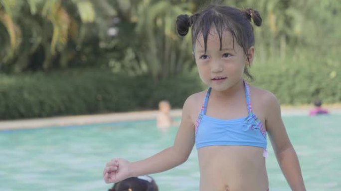 亚洲小男孩和女孩雷莱克斯喜欢在游泳池里打球