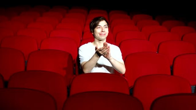 一个人独自坐在空荡荡的电影院或剧院里鼓掌