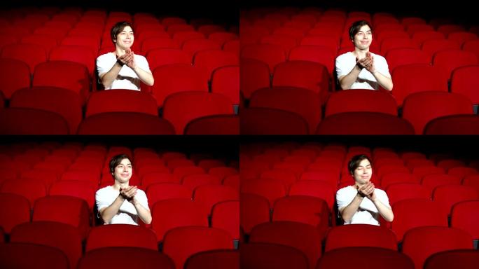 一个人独自坐在空荡荡的电影院或剧院里鼓掌