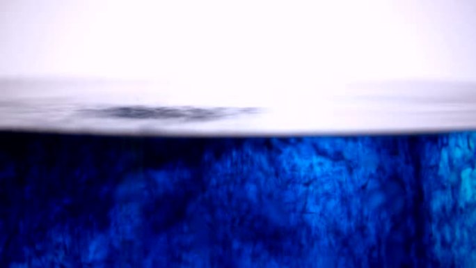 浅蓝色染料溶解在漩涡水浴中