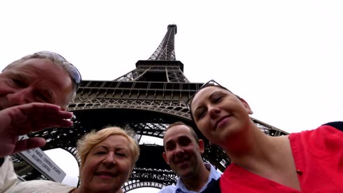 快乐的家庭在巴黎埃菲尔铁塔下玩得开心，并以4k慢动作60fps发送问候