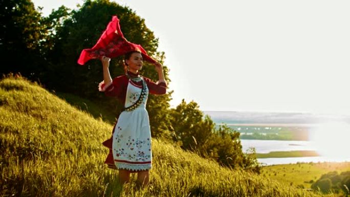 一位穿着俄罗斯民衣的年轻女子站在球场上欣赏美景-将手帕放在她的头上。