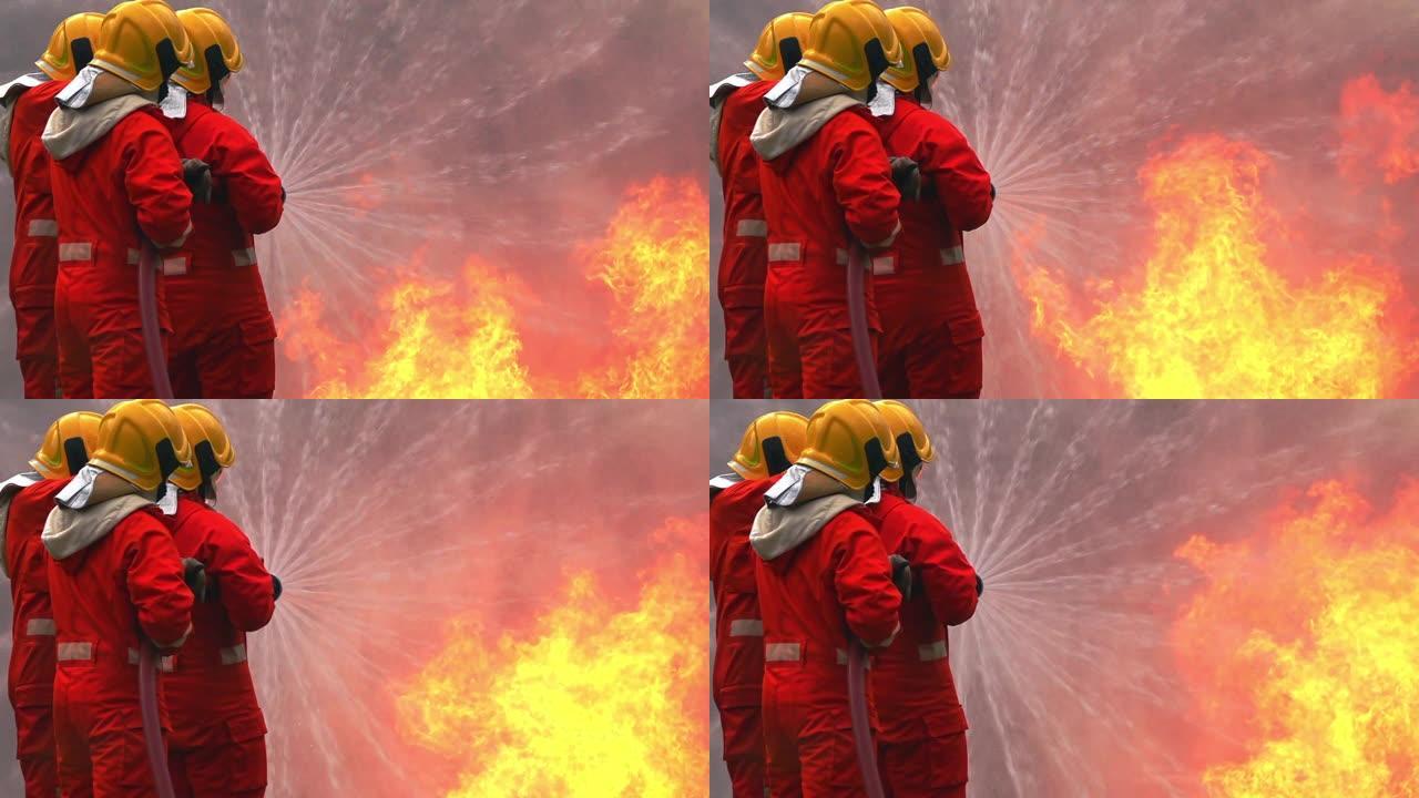 FHD 250 fps慢动作宽镜头消防员在安全救援任务，燃烧区域有裂纹的火焰。三名消防员使用软管中的