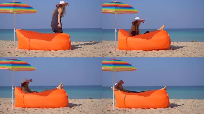热带海滩上的年轻女子躺在充气沙发上。暑假概念