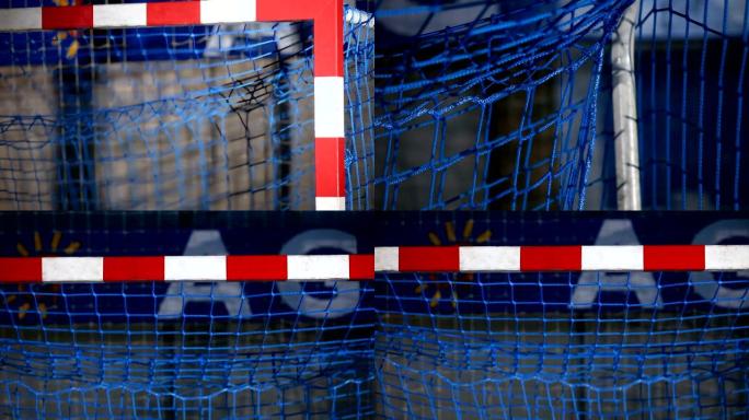 手球球门的视图。网是蓝色的，红色和白色的框架。
