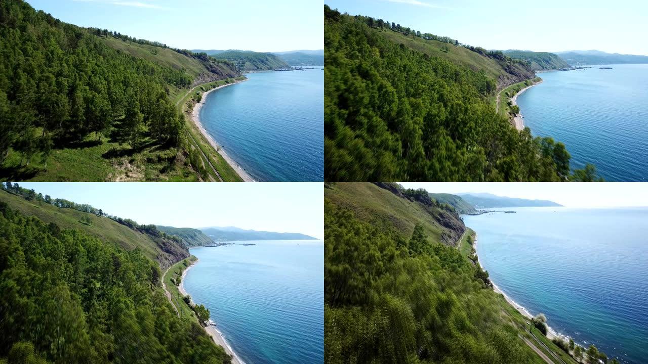 贝加尔湖最古老。俄罗斯西伯利亚铁路。高山松林夏日阳光普照碧水。美丽的空中跟随湖泊。快速空中无人机4k