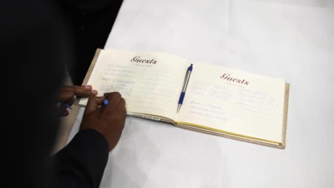 特写，hand在婚礼上的祝贺书中写祝贺