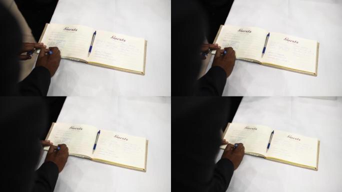 特写，hand在婚礼上的祝贺书中写祝贺