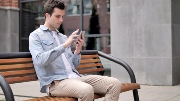 休闲年轻人使用智能手机坐在户外