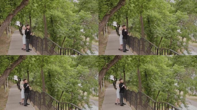 恋爱中的幸福夫妻站在树下公园的后裔上