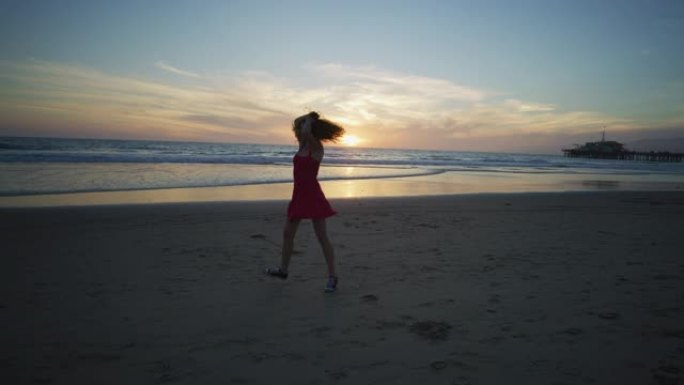日落时分，圣莫尼卡海滩上热情的女孩