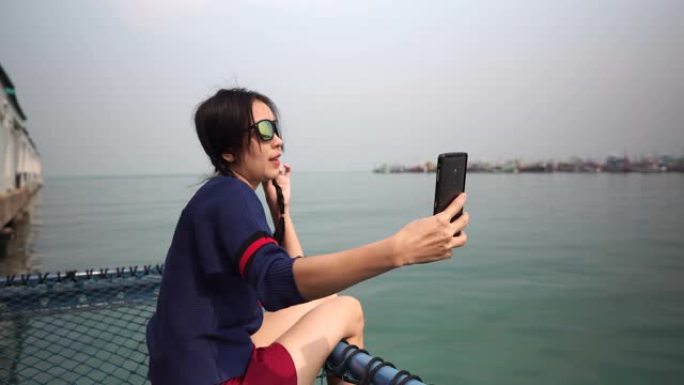 坐在海边自拍的亚洲女孩