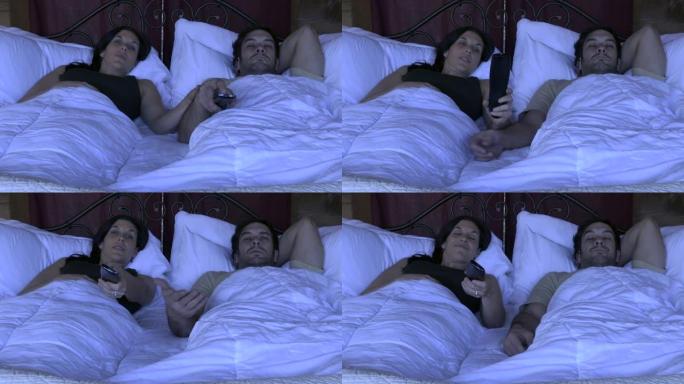 女人与男人躺在床上时用电视遥控器换频道