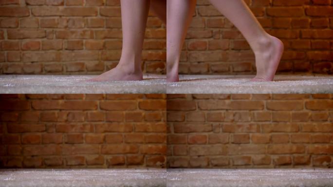 在砖墙背景上的毛茸茸的地毯上，女性双腿向左缓慢行走的特写镜头。