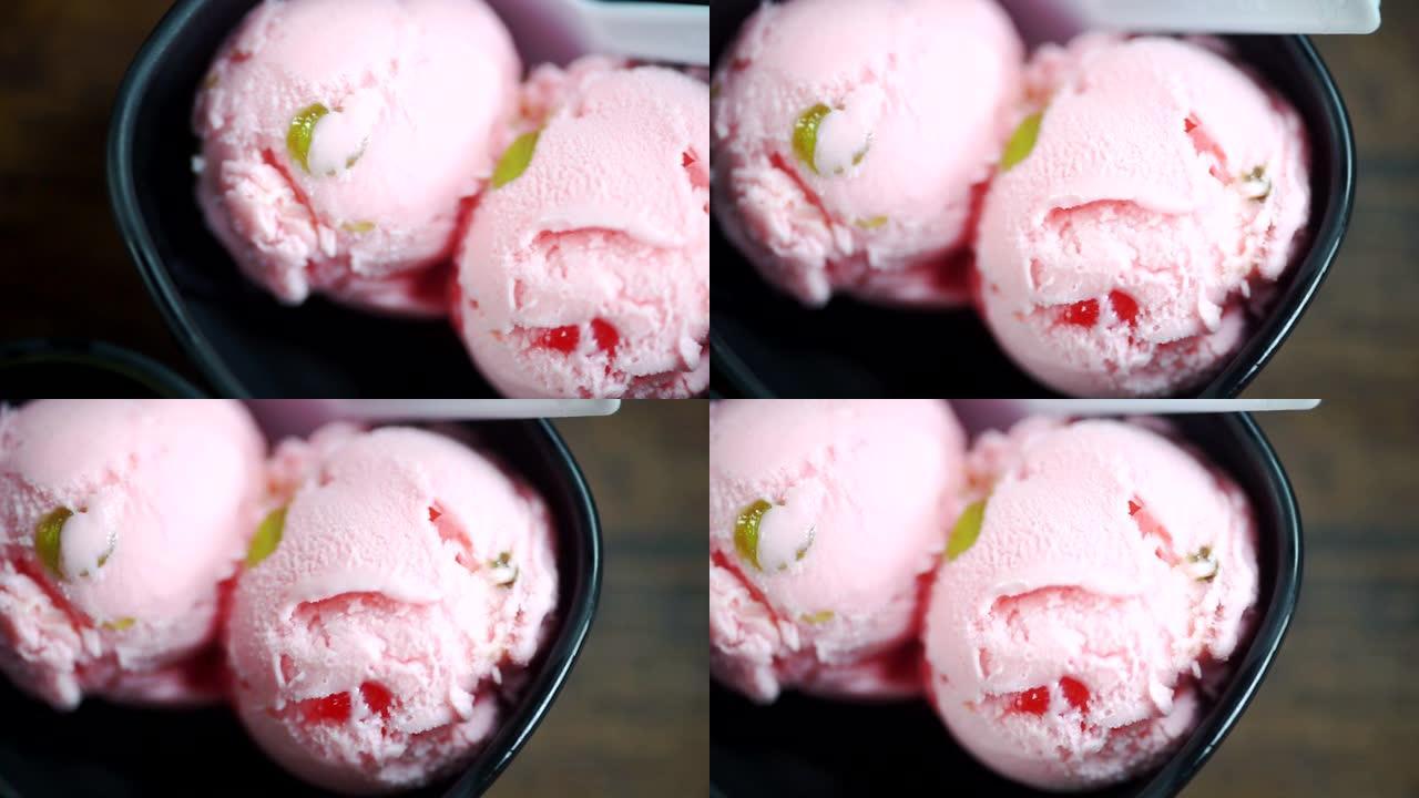 桌子上黑色碗里的草莓冰淇淋。