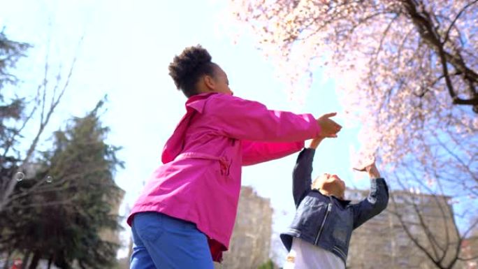 孩子们奔跑并试图抓住肥皂泡