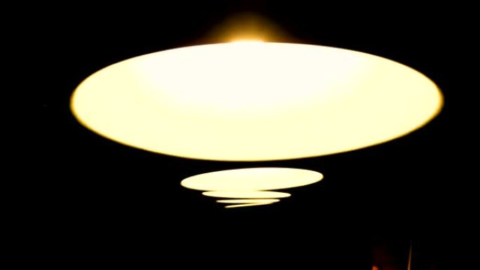 台球桌上方有黄光的灯具。