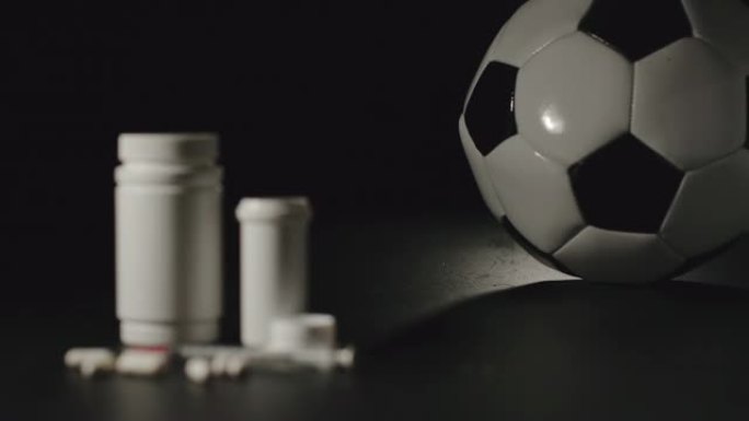 慢动作: 用药丸在白盒旁边滚动的足球球