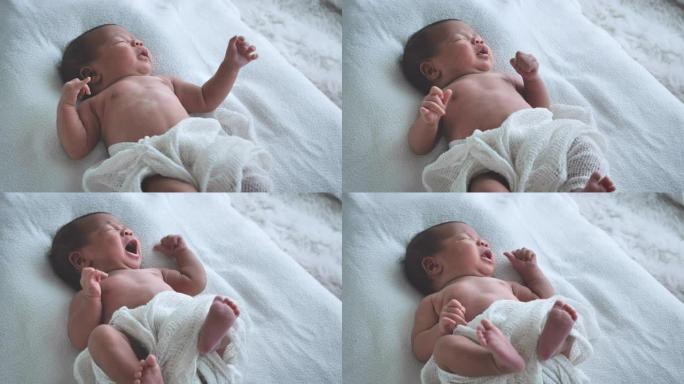 亚洲女性新生婴儿躺在床上，早晨晒太阳。可爱的小女孩三周大。微笑、哭泣、扭动、情感概念