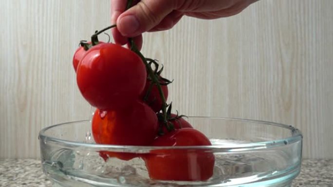 厨师从带水的碗里拿西红柿。慢动作。