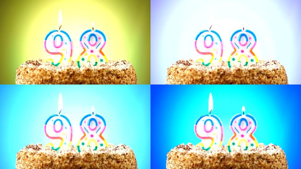 带有燃烧的生日蜡烛的生日蛋糕。98号。背景改变颜色
